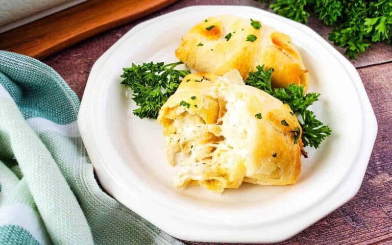 Chicken crescent rolls on a white plate with parsley.
