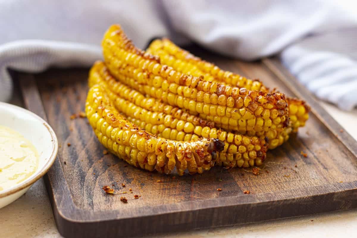 Cooked air fryer corn ribs stacked on a chopping board