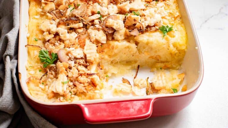 A casserole dish filled with chicken and cheese.