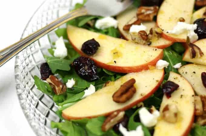 A salad with apples, walnuts and cranberries.