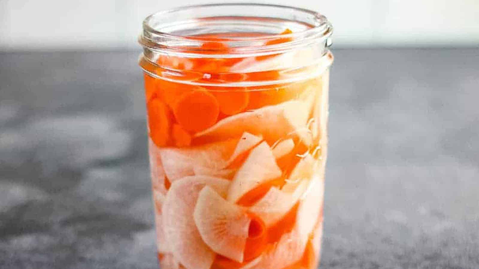 Low angle shot of a jar of pickled daikon radish and carrots.