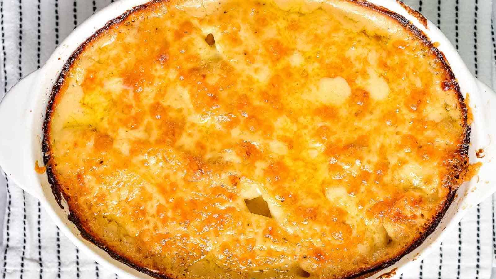 Overhead shot of potatoes au gratin cooked in an oval baking dish.