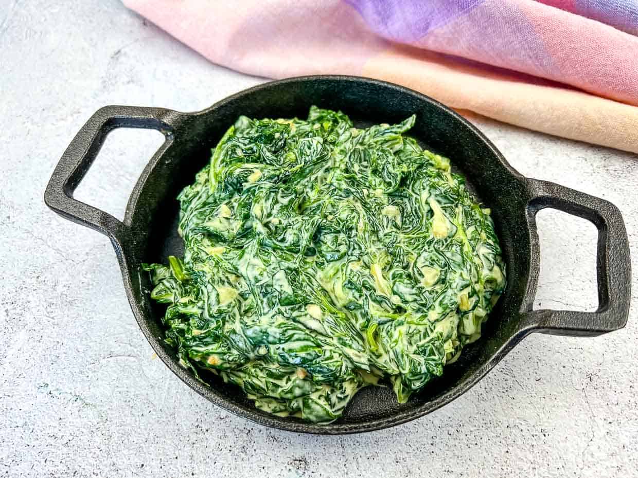 Creamed Spinach with Mascarpone in a black dish.