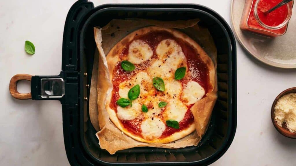 An air fryer with a pizza in it.