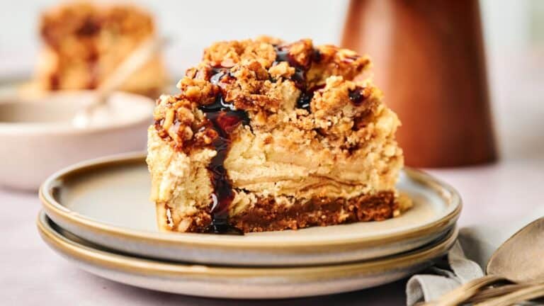 A slice of cheesecake on a plate with a spoon.