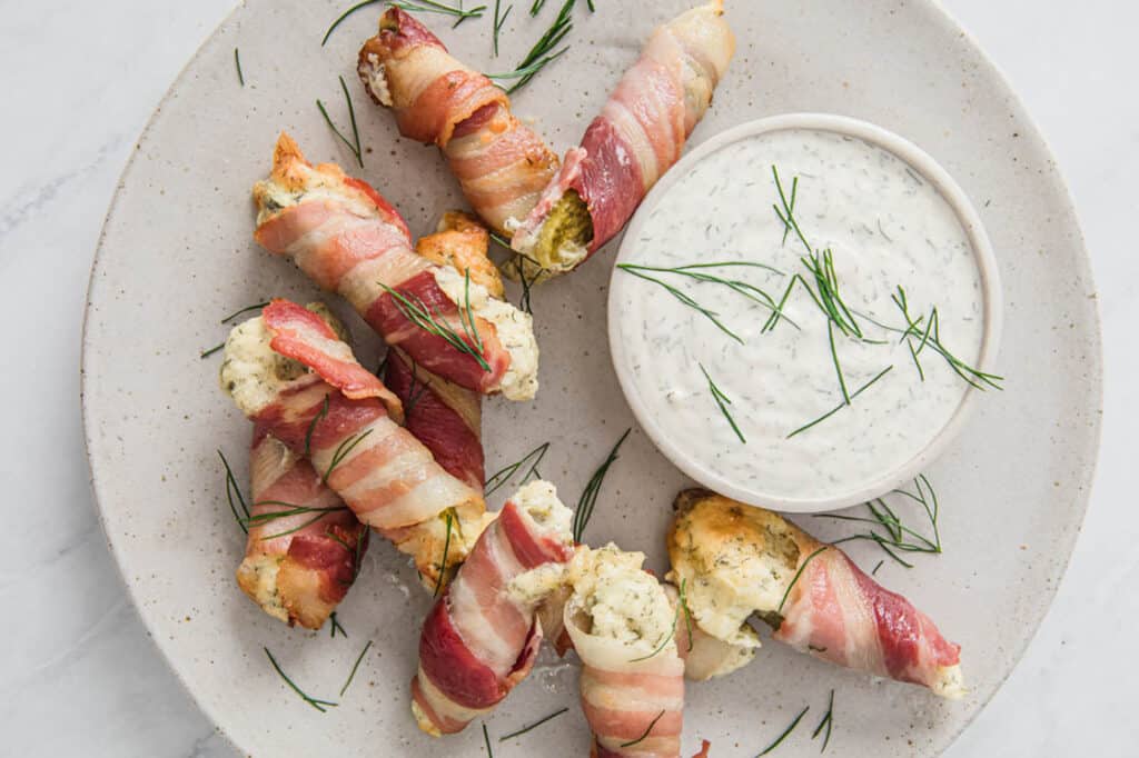 Bacon pickle boats stuffed with cream cheese with dipping sauce.