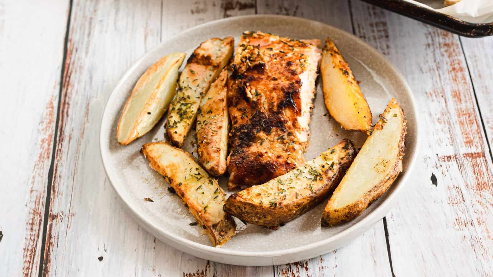 Grilled salmon and potatoes on a plate.