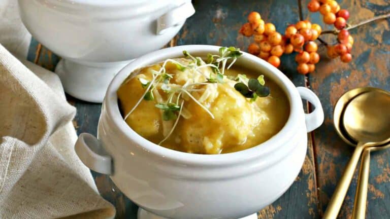 Two bowls of soup on a wooden table.