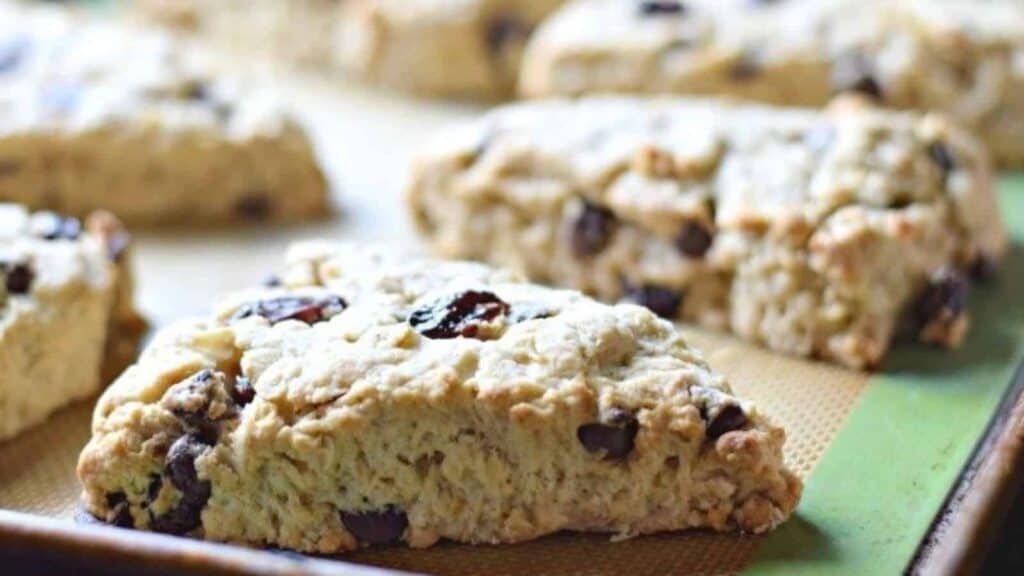 Image shows Cherry Chip Scones on a baking sheet with the sun coming in from the back.