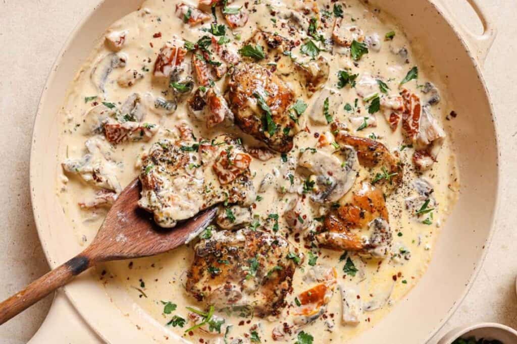 A skillet with chicken in a creamy mushroom sauce.
