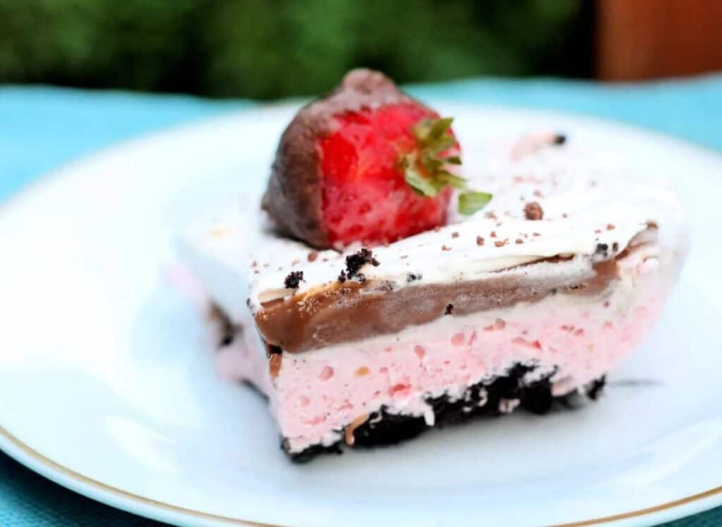 Piece of strawberry dessert on a white plate, closeup.