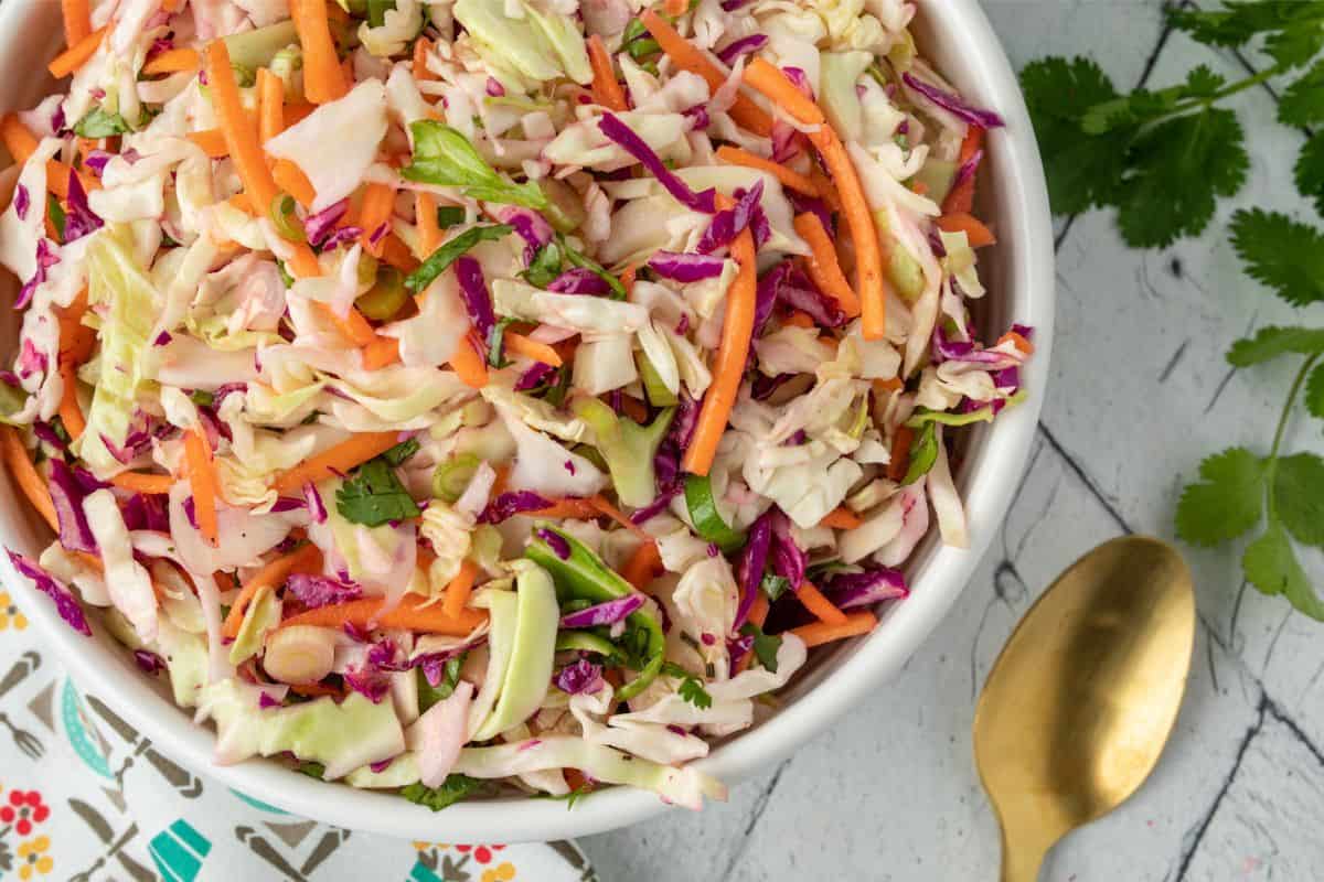 A close up image of cilantro lime coleslaw in a bowl