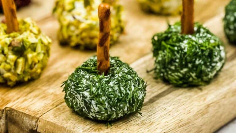 Mini Goat cheese balls on a wooden cutting board.