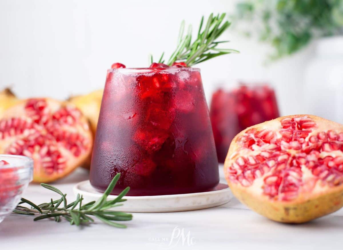 A refreshing cocktail made with pomegranate juice and garnished with rosemary sprigs.