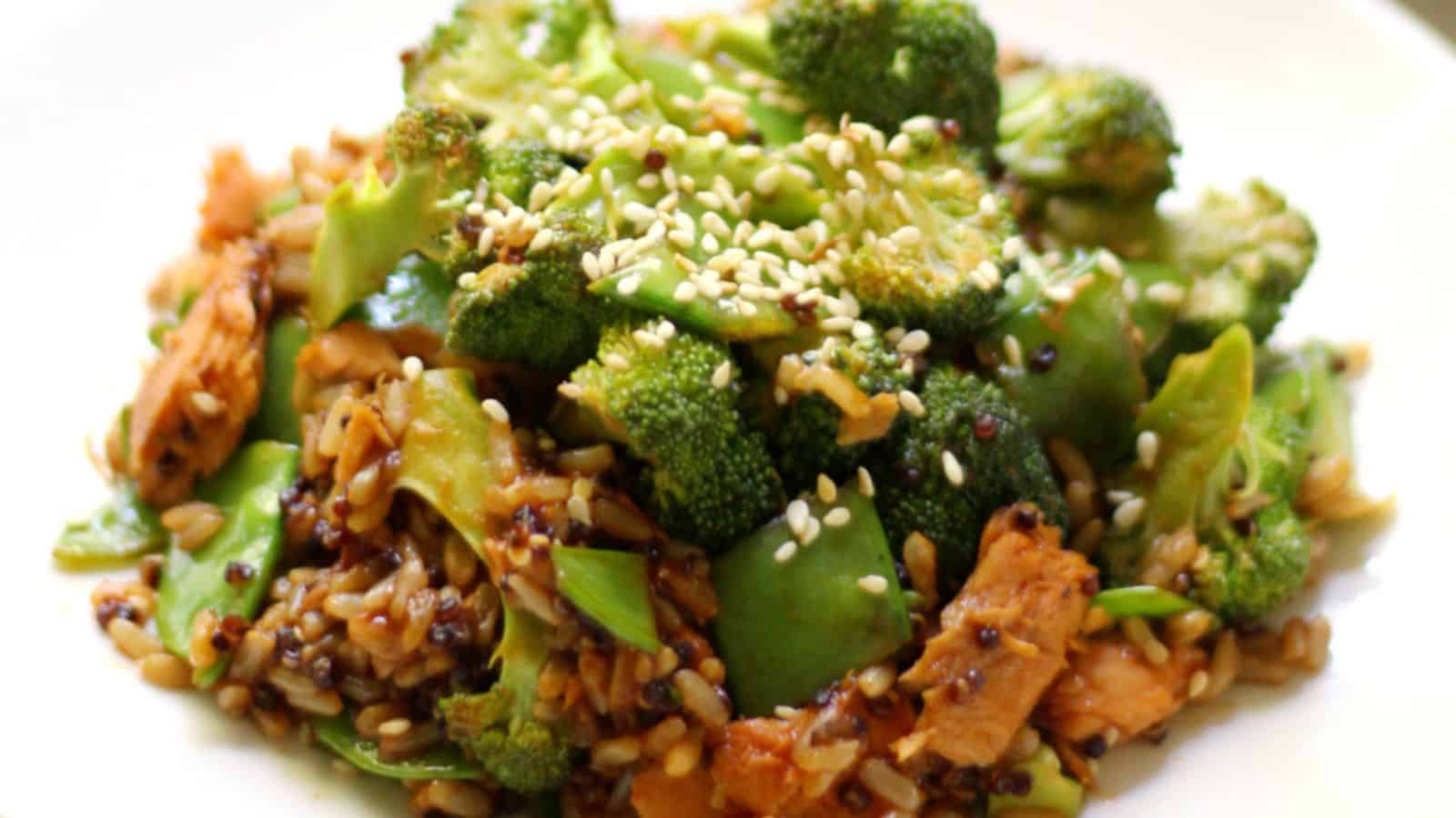 A plate with broccoli, salmon and sesame seeds.
