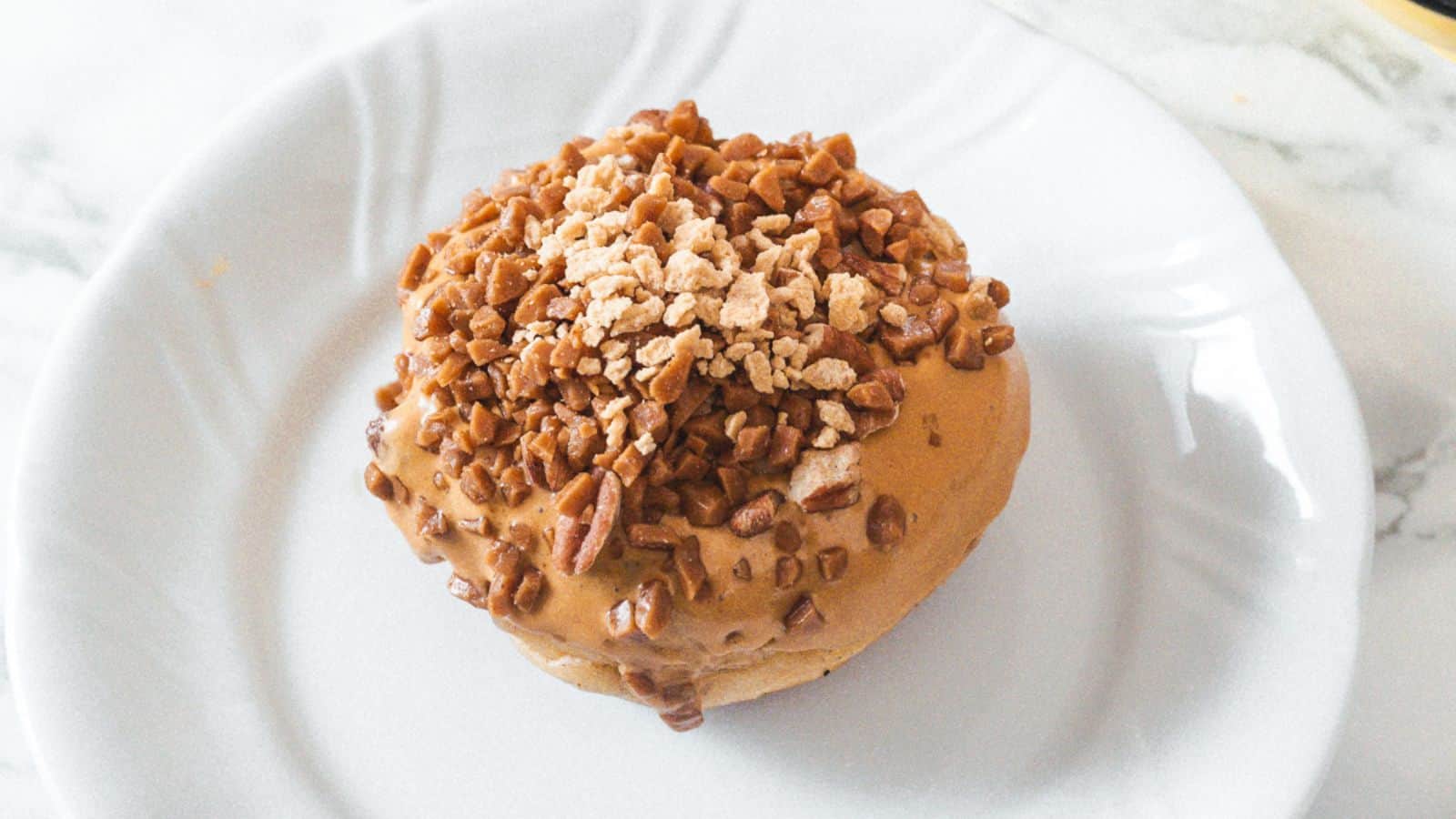 A peanut butter doughnut on a white plate.