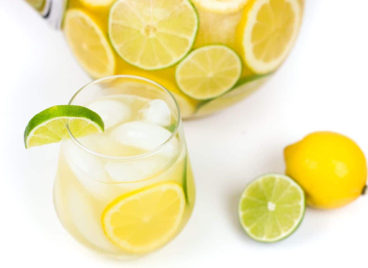 A pitcher of margarita sangria with slices of lemons and limes.