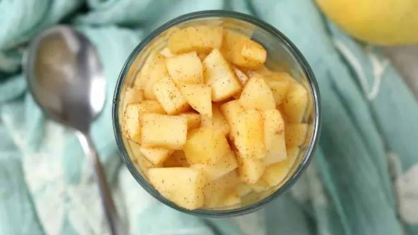 Overhead shot of bowl of cinnamon apples with a spoon.