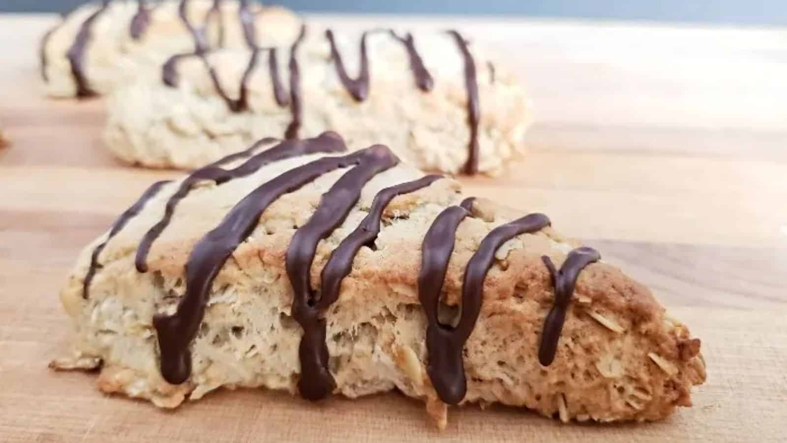 Image shows Chocolate drizzled mocha scones on a cutting board.