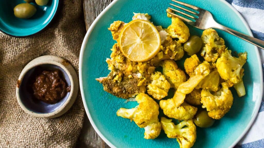 A plate of roasted cauliflower with lemon and olives.