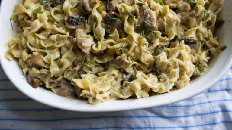 A dish of pasta with mushrooms and herbs.