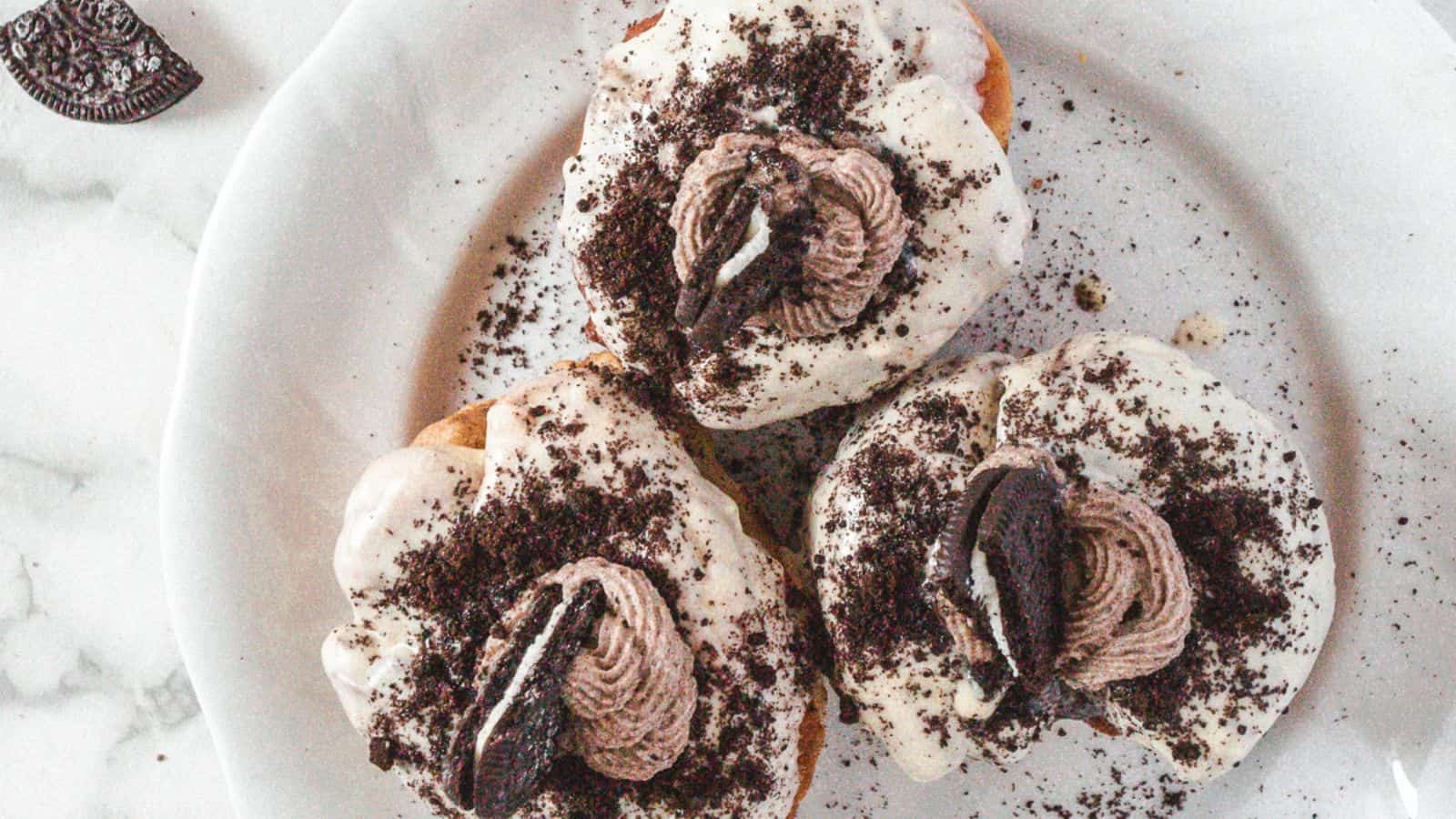 Oreo donuts on a plate with icing and oreos.
