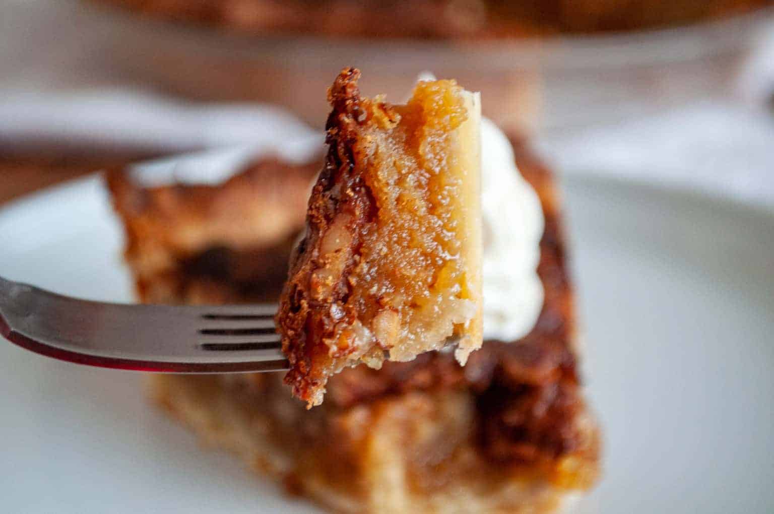 A bite pecan pie on a fork.
