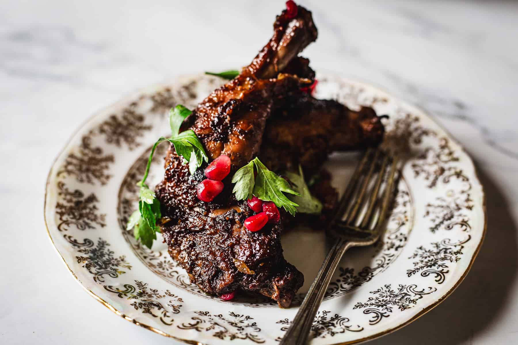 Roasted lamb chops with pomegranate on a plate.