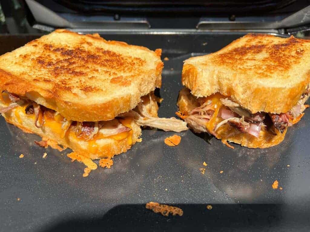 A pulled pork grilled cheese sandwich on a slate plate.