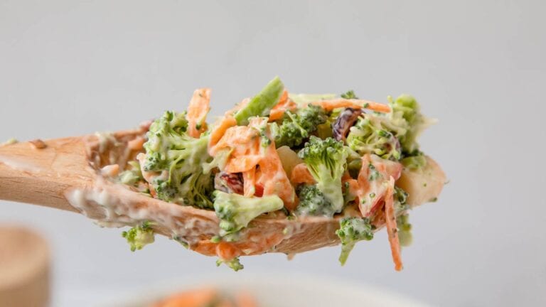 Broccoli and shredded carrots on a mixing spoon.