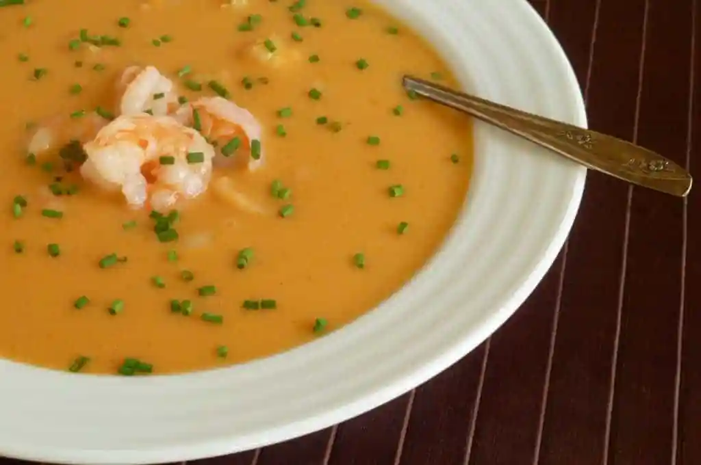 A bowl of soup with shrimp in it.