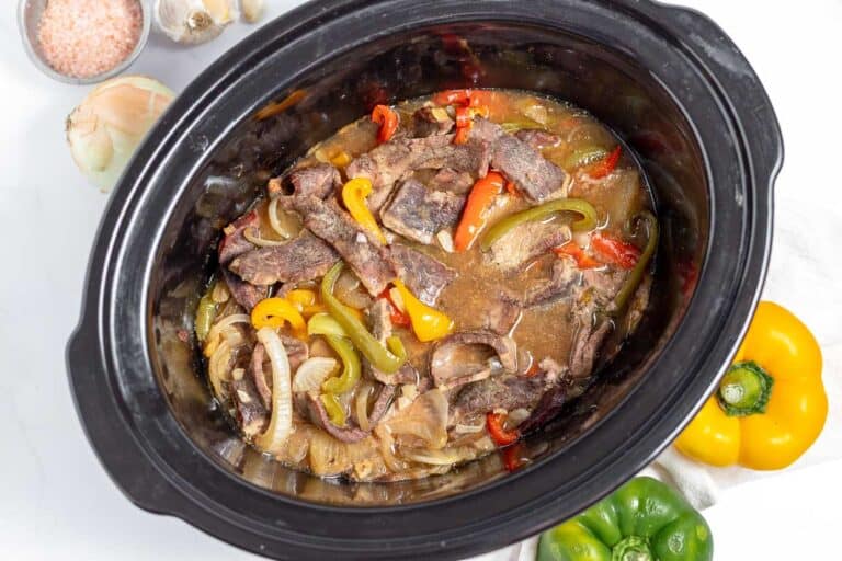 A warm crock pot filled with succulent beef and flavorful peppers, perfect for cozy winter dinners.