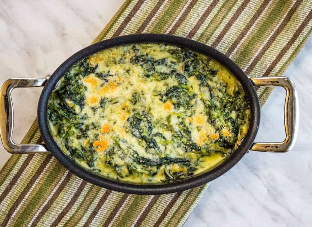 Steakhouse Creamed Spinach in a black dish on a cloth.