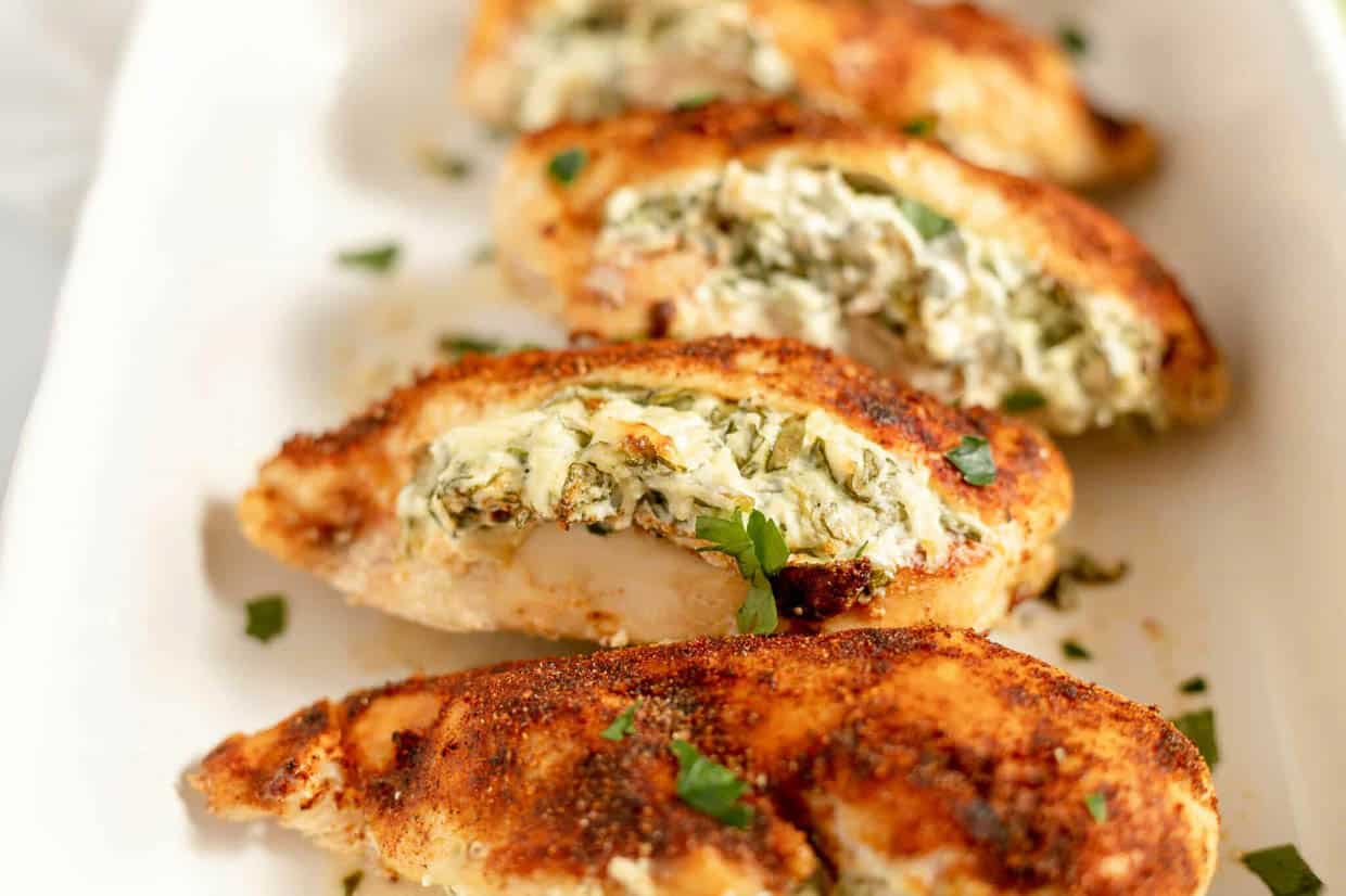 A baking dish full of stuffed chicken breasts.