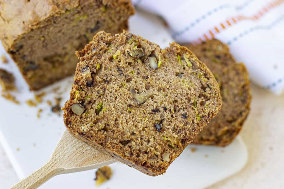 A slice of old-fashioned zucchini bread on a white plate.