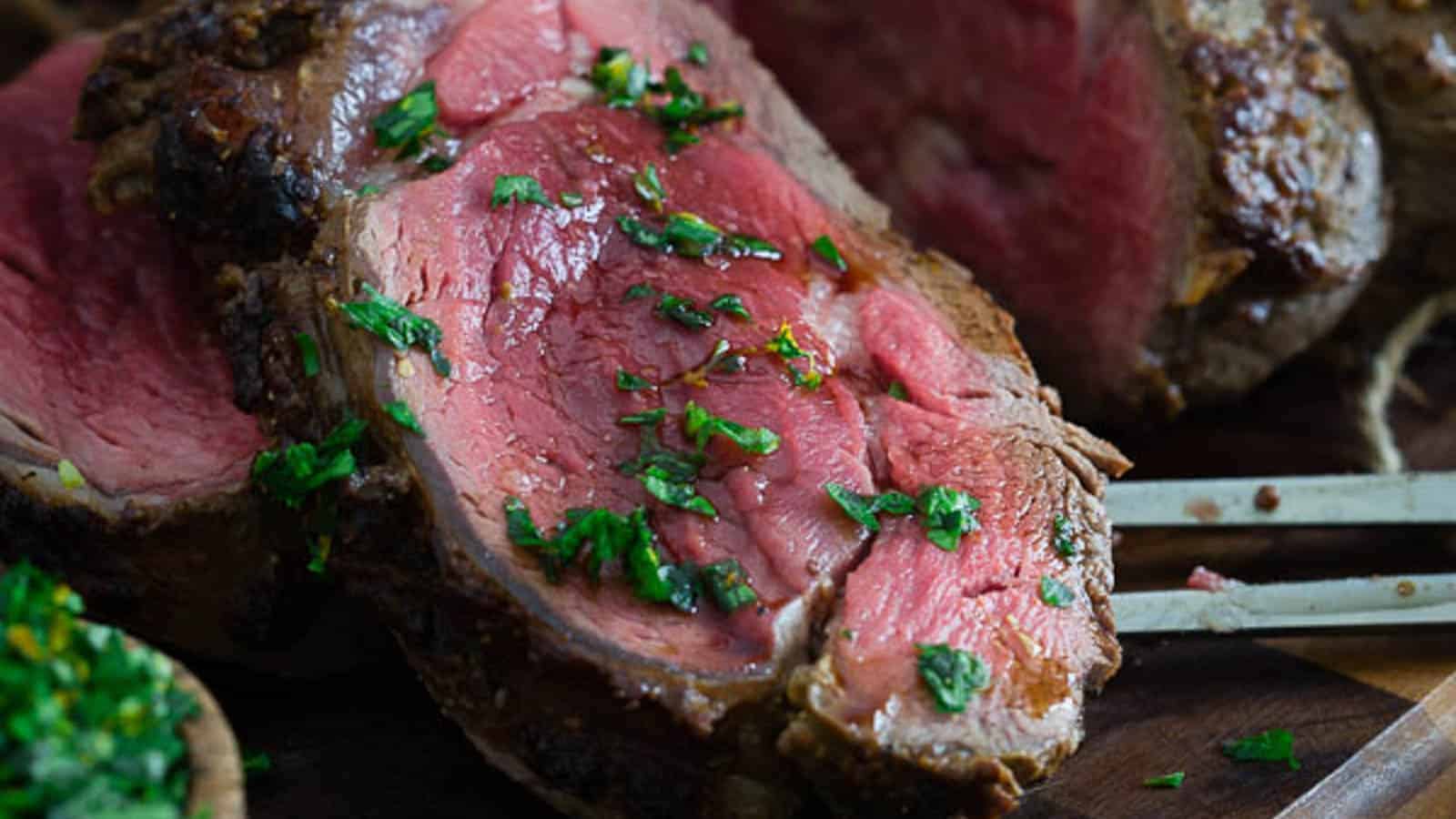 Balsamic Dijon crusted beef tenderloin sliced on a cutting board.