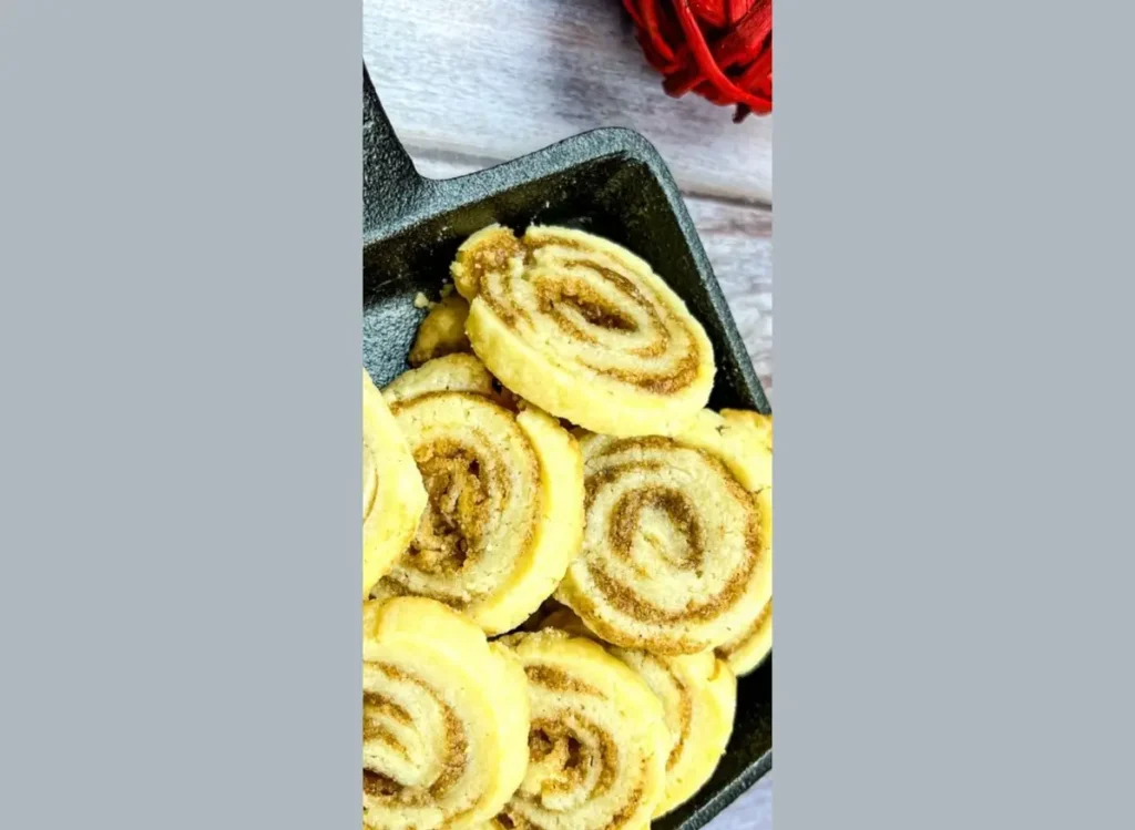 Cinnamon rolls in a skillet on a wooden table.