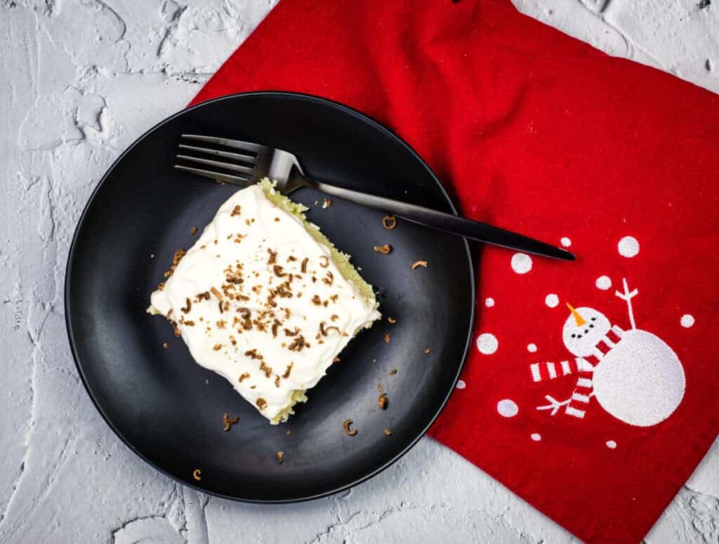 A slice of Eggnog Tres Leches Cake on a plate.