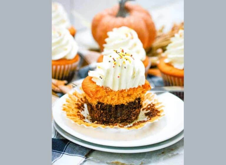 Pumpkin cupcakes with whipped cream on a plate.