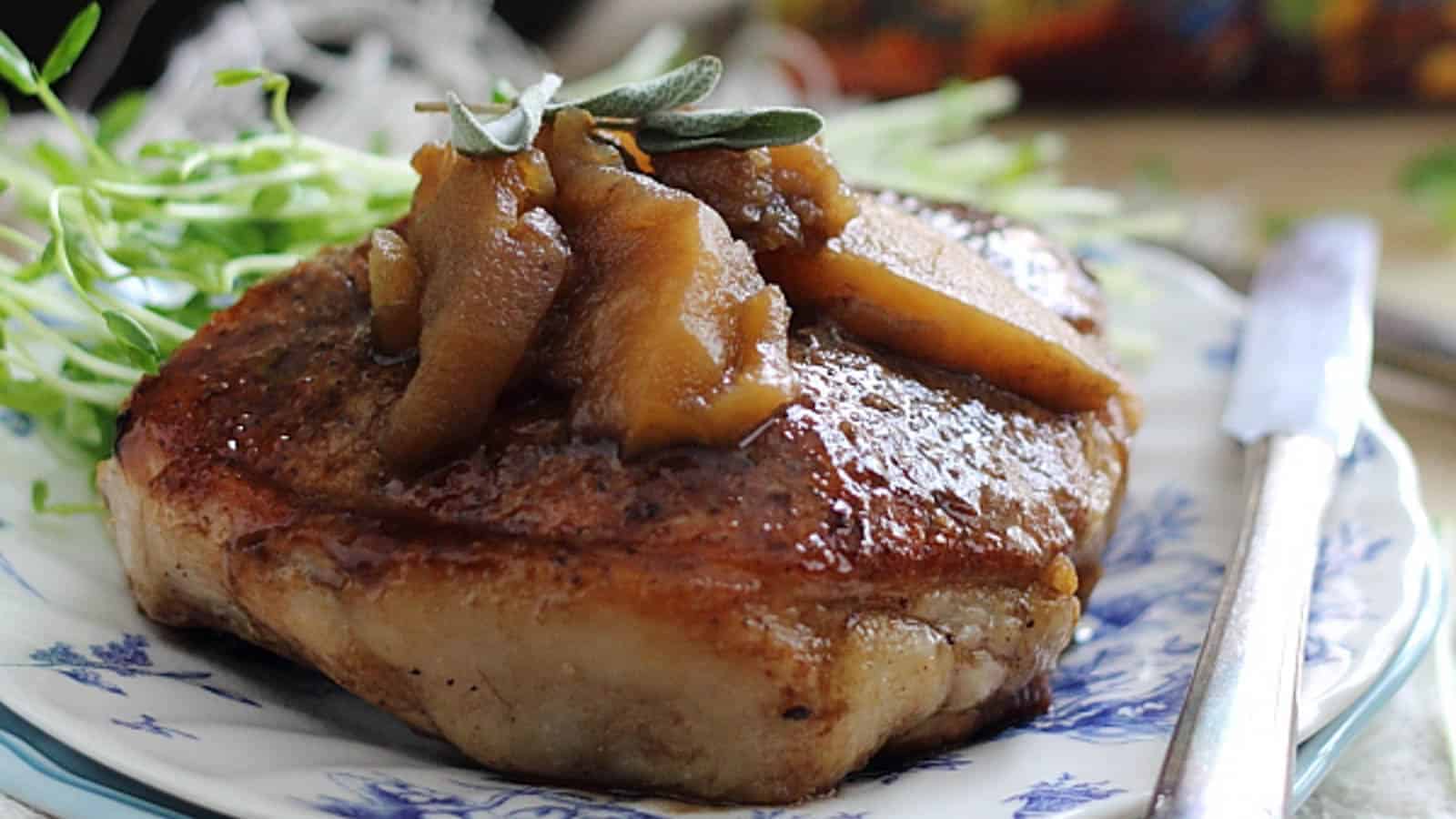 Tea glazed pork chops with sauteeed apples on top and sage garnish.