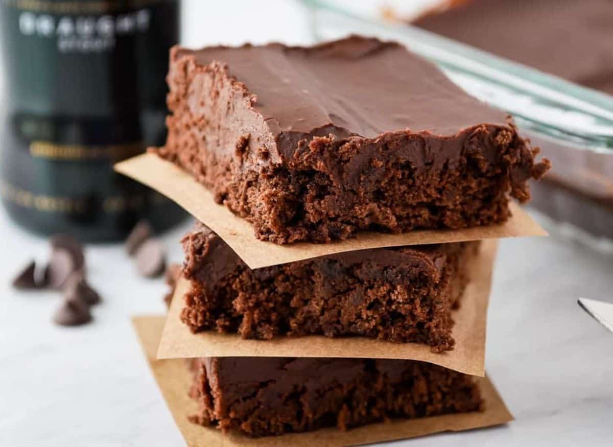 Stack of Guinness brownies with a bottle of Guinness in the background.