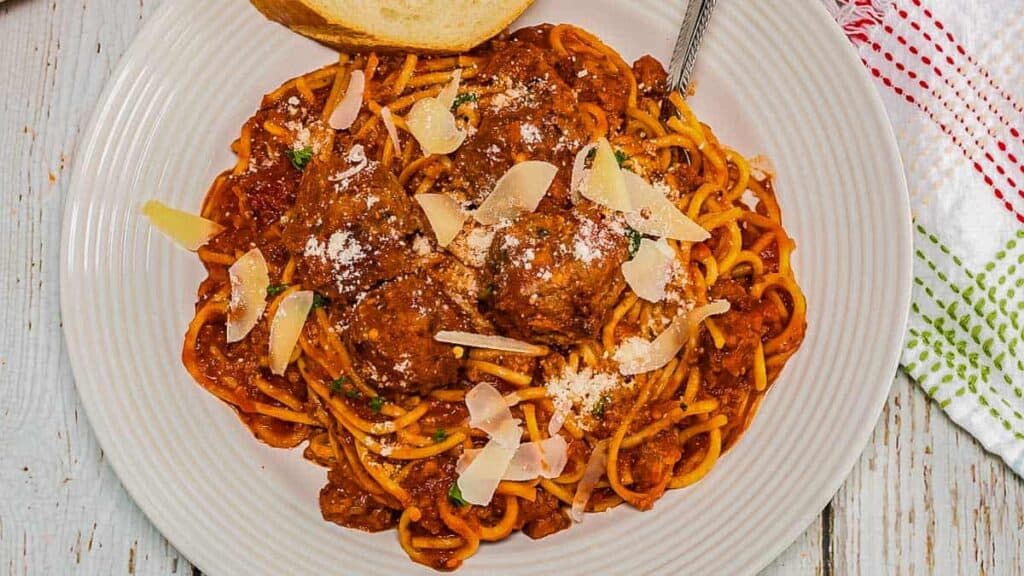 Spaghetti with meatballs on a white plate.