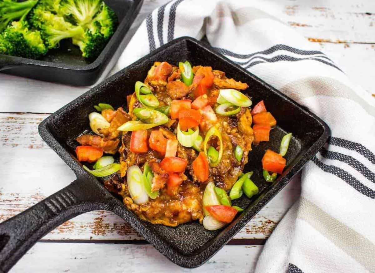 Chicken dish with vegetables in a square pot.