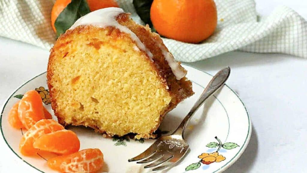 A slice of orange bundt cake on a plate.