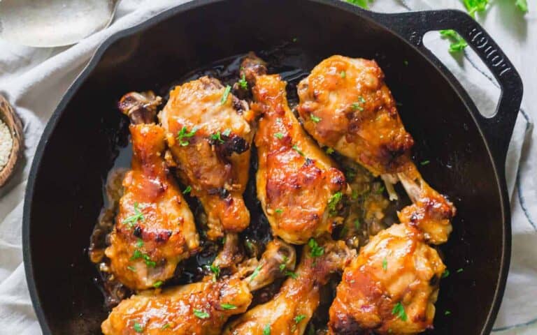 Chicken legs in a cast iron skillet.