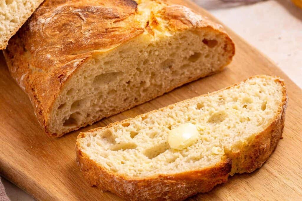 A loaf of bread on a wooden cutting board.