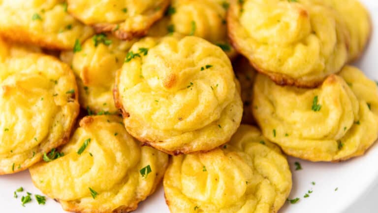 A plate with a plate of fried biscuits with parsley.