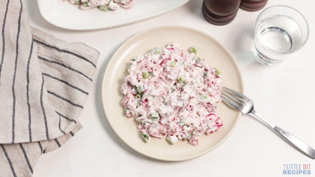 Easy Radish Salad on plate with glass of water.