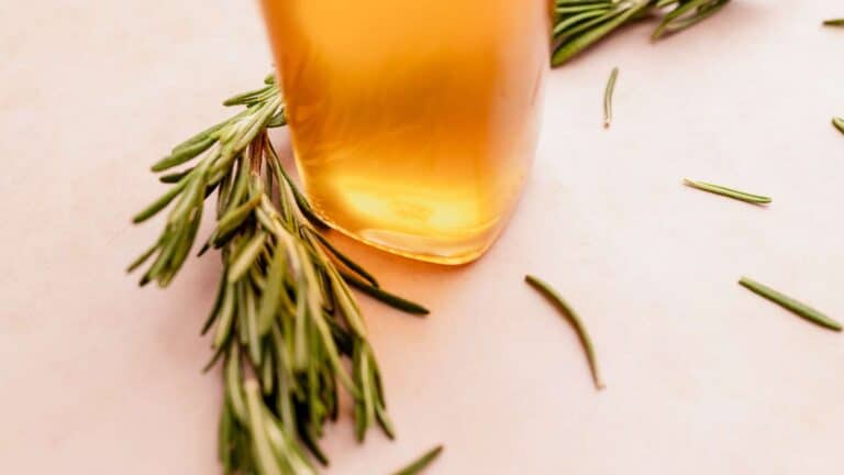 A sprig of rosemary adds a delightful touch to this bottle of syrup, making it an exquisite option for edible gifts.
