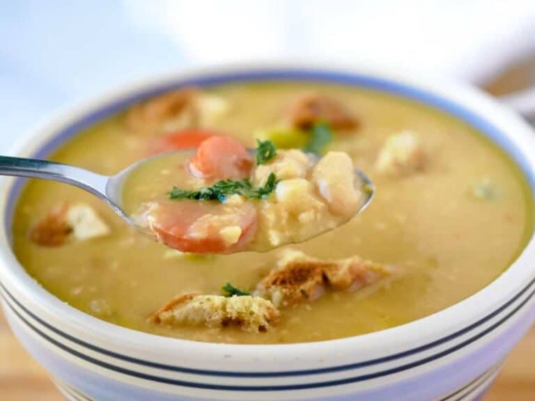 A spoonful of soup with croutons in it.